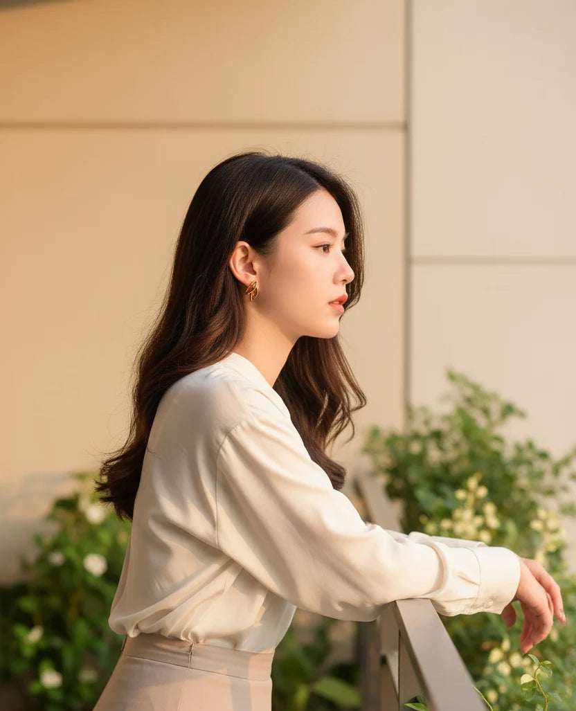 Gold Double Leaf Stud Earrings worn outdoors in soft sunset profile shot | OriaJewel
