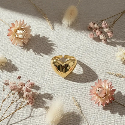 Gold Heart Open Ring styled in a romantic flat lay on textured fabric with dried flowers and warm daylight, focusing on the shiny heart center and open ring gap. | OriaJewel