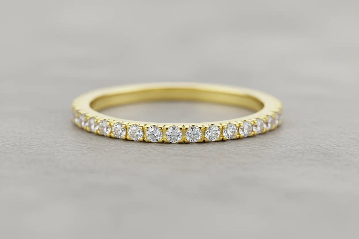 Close-up macro of a slim Gold Midi Ring Set band with a row of sparkling clear stones on a soft gray background | OriaJewel