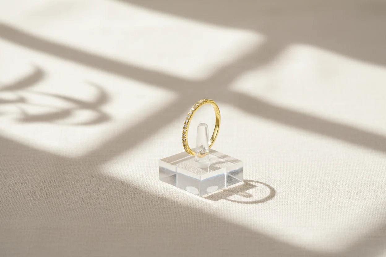 Gold Midi Ring Set displayed on a clear acrylic ring stand with dramatic window-light shadows across a textured neutral backdrop | OriaJewel