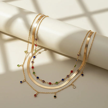Gold Multilayer Choker Necklace featuring colorful gemstones on layered chains, perfect for elegant styling | Oria Jewel