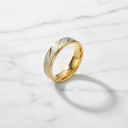 Gold Silver Two Tone Band Ring on white marble surface with crisp soft shadow, brushed silver top with diagonal gold accents, premium minimal look | OriaJewel