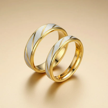 Two-ring set photo featuring Gold Silver Two Tone Band Ring designs, brushed silver bands with diagonal gold detailing, polished gold interiors, soft warm backdrop | OriaJewel