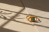 Gold Turquoise Adjustable Open Ring styled on fabric under window-grid shadows, emphasizing the gold geometric frame, sunburst texture, and turquoise center stone in natural light | OriaJewel