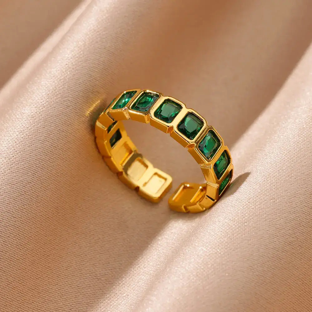 Green stone band ring close-up on soft beige fabric, macro detail showing the open adjustable band design and the row of rectangular green stones | OriaJewel