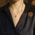 Woman wearing a Love Heart Pendant Necklace with a dark satin blouse, softly lit for an elegant look | Oria Jewel