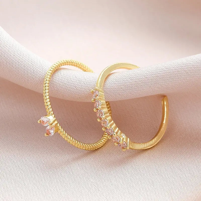 Luna Dainty Stack Ring Set close-up on pale fabric, showing the two adjustable open rings with a marquise cluster detail and a row of small crystals on a slim gold band | OriaJewel