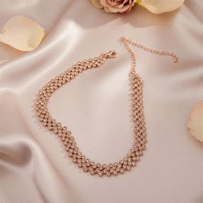 Luxury Rhinestone Chain Choker in rose gold placed on satin fabric with flower petals, exuding feminine charm | Oria Jewel