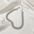 Luxury Rhinestone Chain Choker laid out on ivory satin fabric, highlighting sparkle and craftsmanship | Oria Jewel