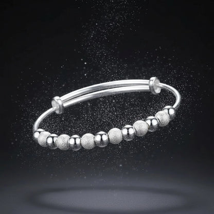 Dramatic shot of the Marvella Beaded Charm Cuff floating against a dark background with shimmering particles, emphasizing its celestial sparkle and modern bead design | Oria Jewel