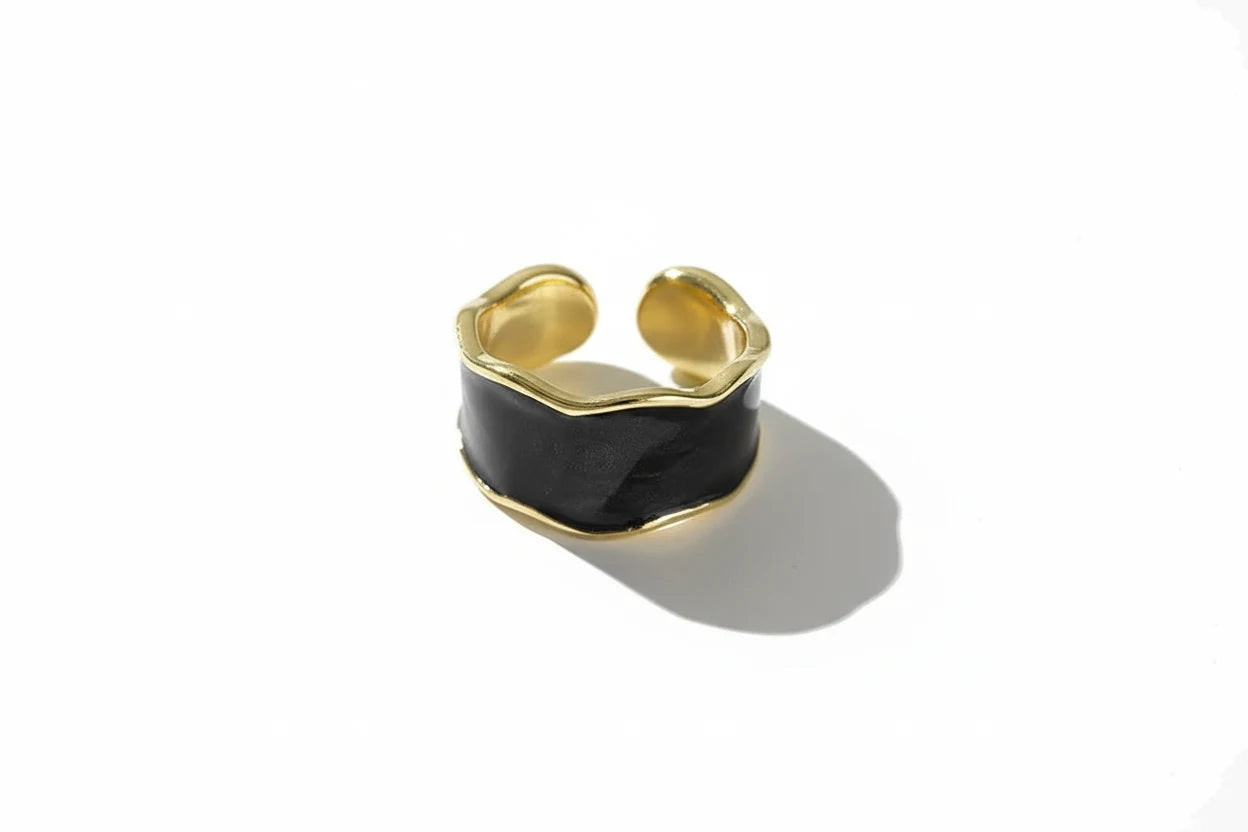 Midnight Black Open Wave Ring product shot on a clean white background, adjustable open wave band with glossy black center and gold-tone borders casting a soft shadow | OriaJewel