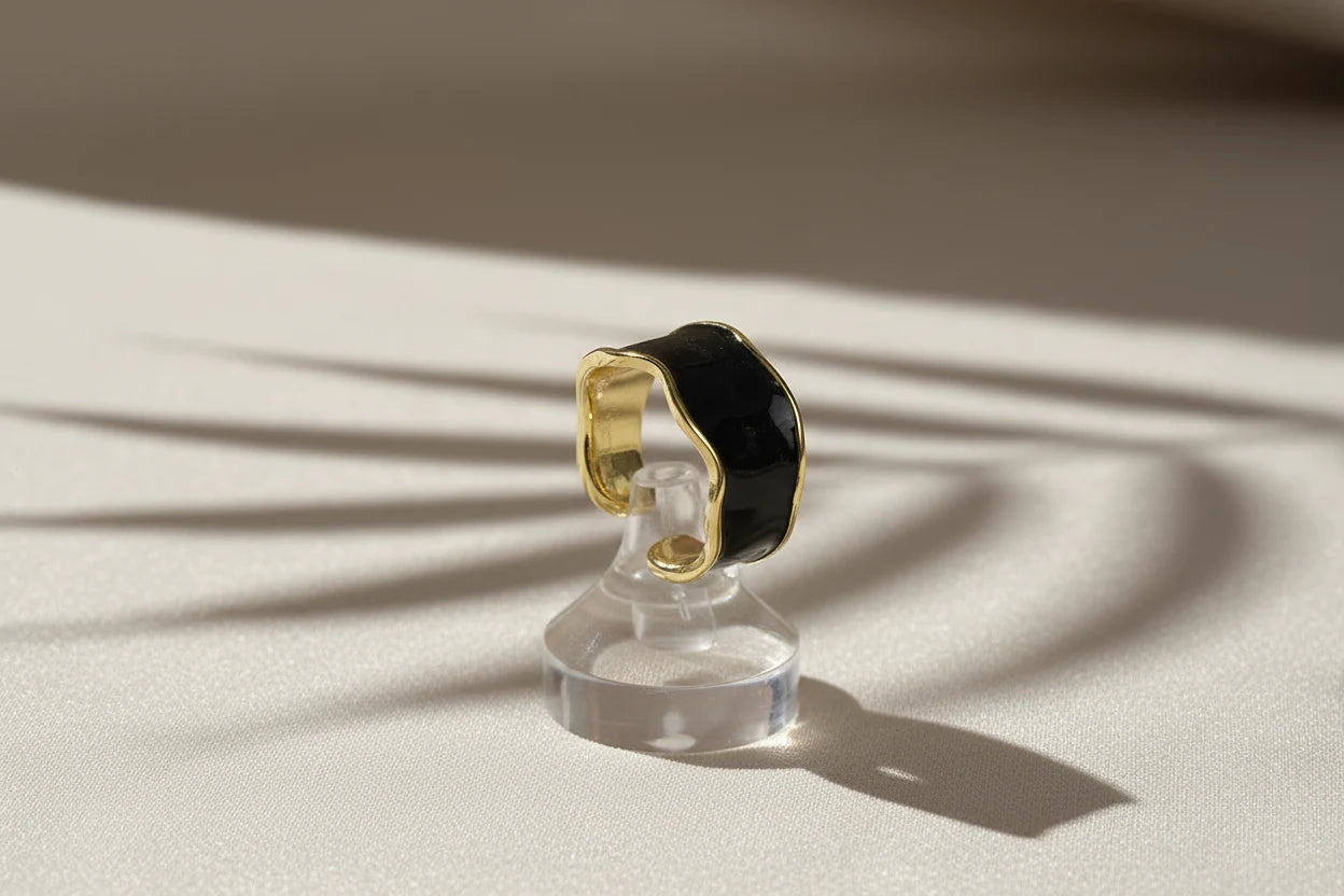 Midnight Black Open Wave Ring on a clear ring stand with dramatic window-shadow lines, black glossy open wave band with gold-tone trim | OriaJewel