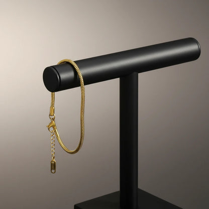 Close-up of Minimalist Gold Chain Bracelet hanging from a modern black jewelry stand against a neutral studio background | Oria Jewel