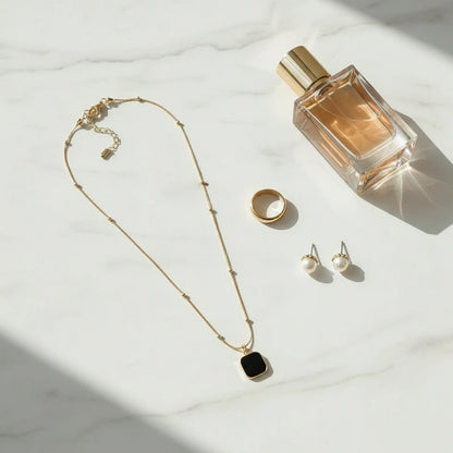 Minimalist Square Pendant Choker displayed with perfume, a ring, and stud earrings on marble surface | Oria Jewel
