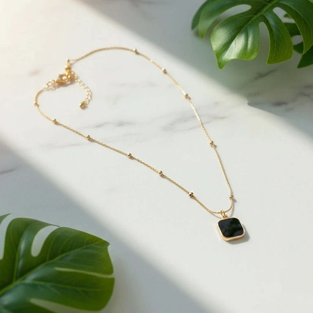 Minimalist Square Pendant Choker on a marble surface with tropical leaves | Oria Jewel