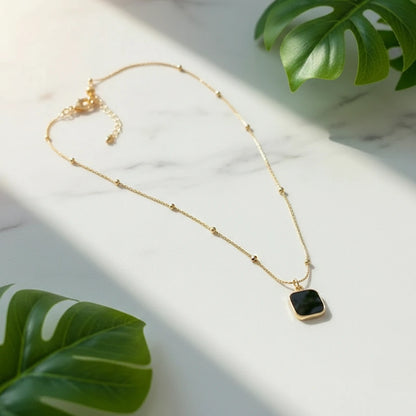 Minimalist Square Pendant Choker on a marble surface with tropical leaves | Oria Jewel