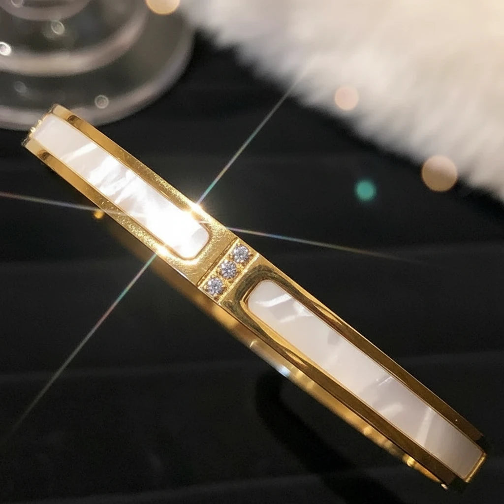Close-up, sparkling macro shot of the Mother of Pearl Gold Bangle against a dark background, focusing on the glossy inlay and trio of tiny crystals that catch the light for a glamorous, gift-worthy look | Oria Jewel