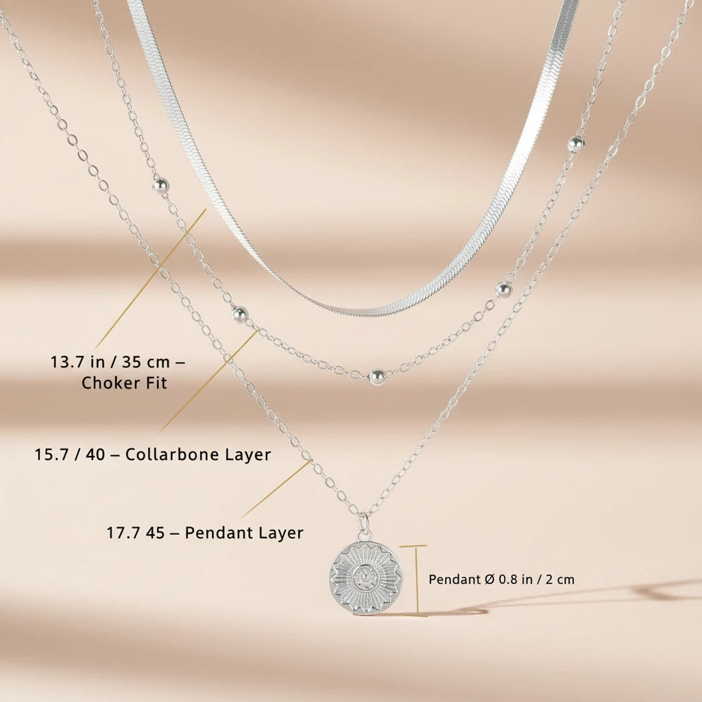 Multi Layer Silver Circle Chain Necklace displayed on beige background with labeled measurements showing choker fit (35 cm / 13.7 in), collarbone layer (40 cm / 15.7 in), pendant layer (45 cm / 17.7 in), and circular pendant size 2 cm / 0.8 in | Oria Jewel