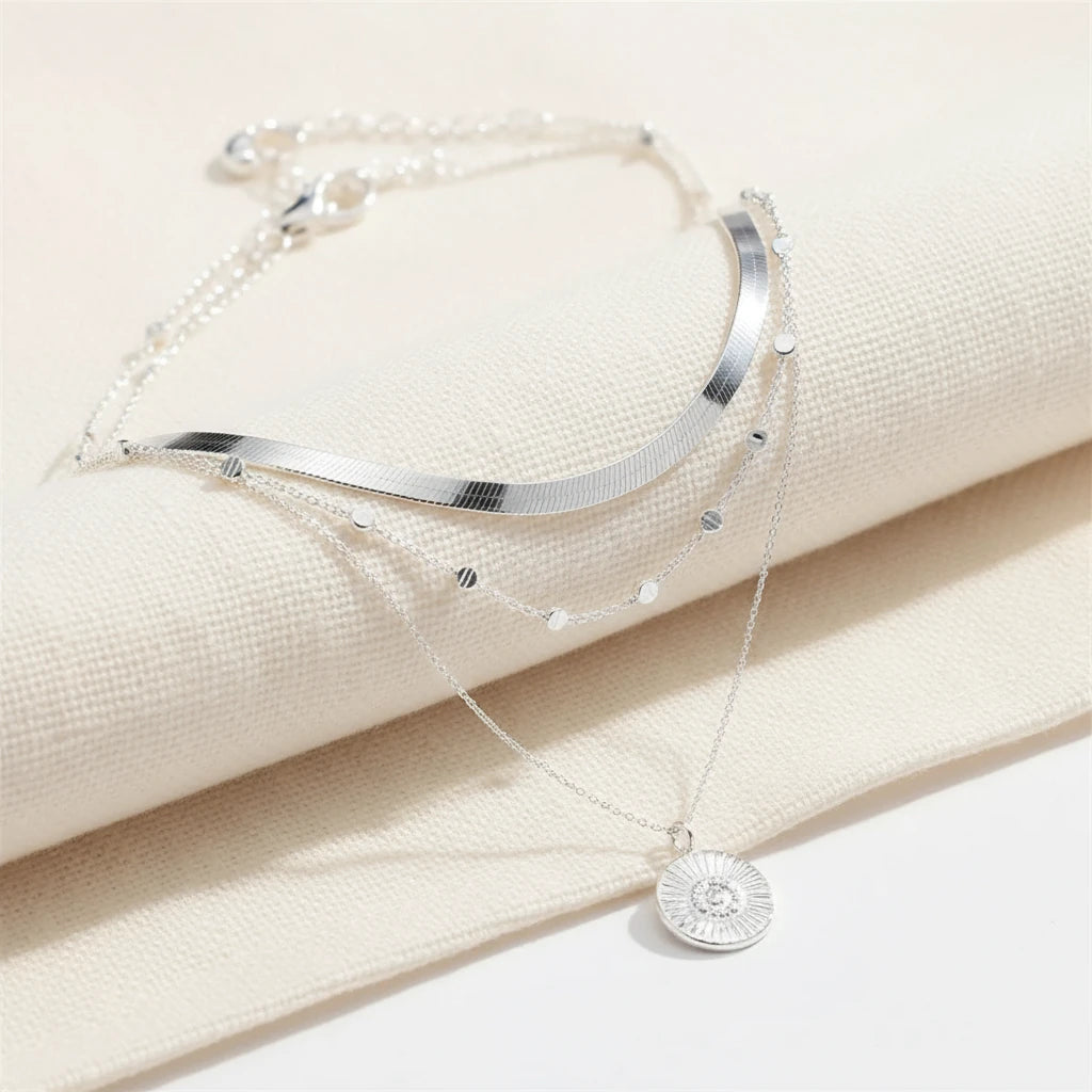 Multi Layer Silver Circle Chain Necklace displayed on soft cream fabric showing detailed layered chains and circle pendant | Oria Jewel