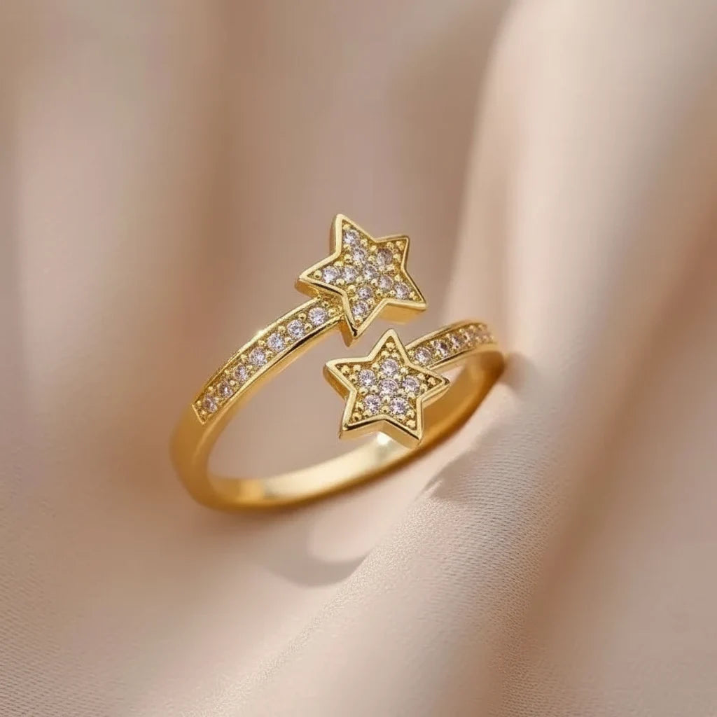 Pavé Double Star Open Ring macro shot on a neutral draped fabric, gold-tone open ring with double star silhouette and bright pavé crystal sparkle in warm light | OriaJewel