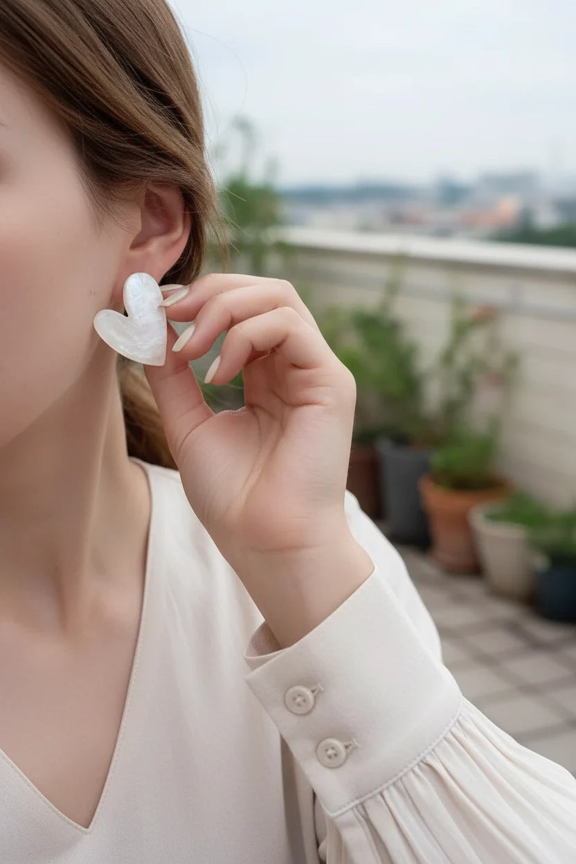 Pearl White Marble Heart Stud Earrings worn by model outdoors close-up | OriaJewel