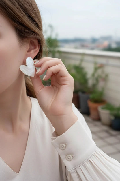 Pearl White Marble Heart Stud Earrings worn by model outdoors close-up | OriaJewel