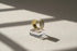 Pearl White Open Wave Ring displayed on a clear acrylic cube with dramatic window shadows, emphasizing the open adjustable band, smooth enamel finish, and gold-trim contour | OriaJewel