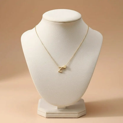Close-up of Personalised Heart Necklace Gold with Z initial and heart charm showcased on a cream jewelry display bust | Oria Jewel