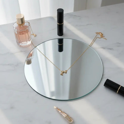 Personalised Heart Necklace Gold with Z initial draped over a round mirror on marble vanity beside perfume and makeup accessories | Oria Jewel