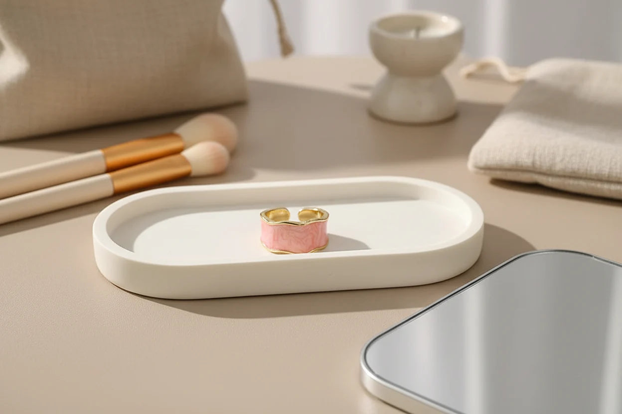 Pink Marble Open Wave Ring centered on a white oval tray with makeup brushes and a mirror nearby, minimal vanity setup with soft warm lighting and clean modern styling | OriaJewel