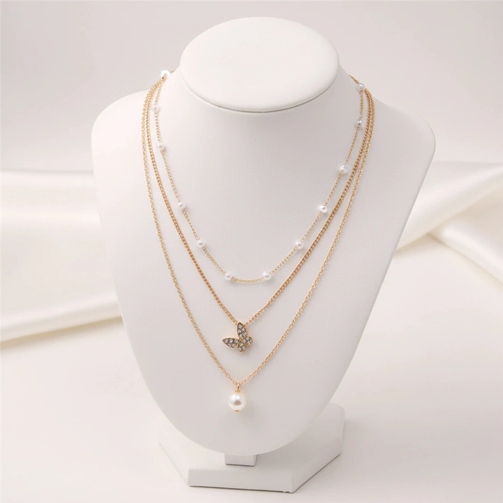 Retro Butterfly Chain Set displayed on a jewelry stand, featuring layered gold chains and butterfly pendant.