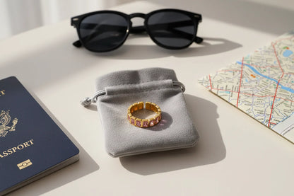 Rose stone band ring styled on a gray pouch with passport, map, and sunglasses travel flat lay | OriaJewel