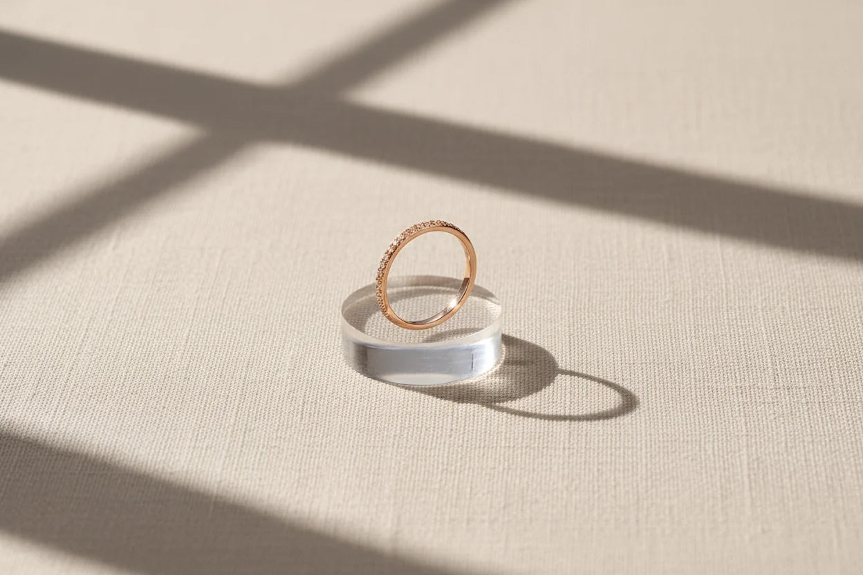 Rose Midi Ring Set rose-gold pavé band displayed on a clear acrylic stand with dramatic window-shadow sunlight on fabric | OriaJewel