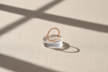 Rose Midi Ring Set rose-gold pavé band displayed on a clear acrylic stand with dramatic window-shadow sunlight on fabric | OriaJewel