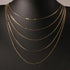 Gold flat chain choker displayed on a black mannequin bust, showcasing its sleek and minimalist design | Oria Jewel