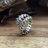 Close-up: shiny silver Fierce Vertebrae Open Band Ring on rustic wood | Oria Jewel