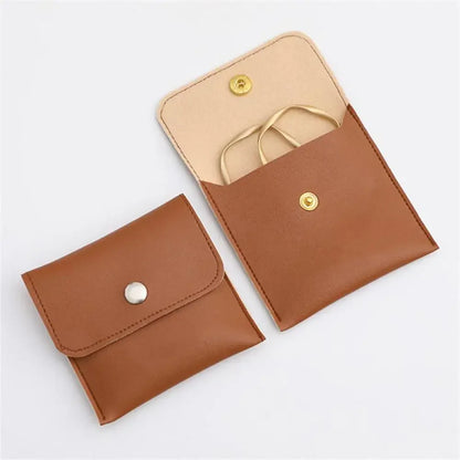 Soft Snap Jewelry Pouch in brown, showcasing a stylish design for storing earrings and rings.