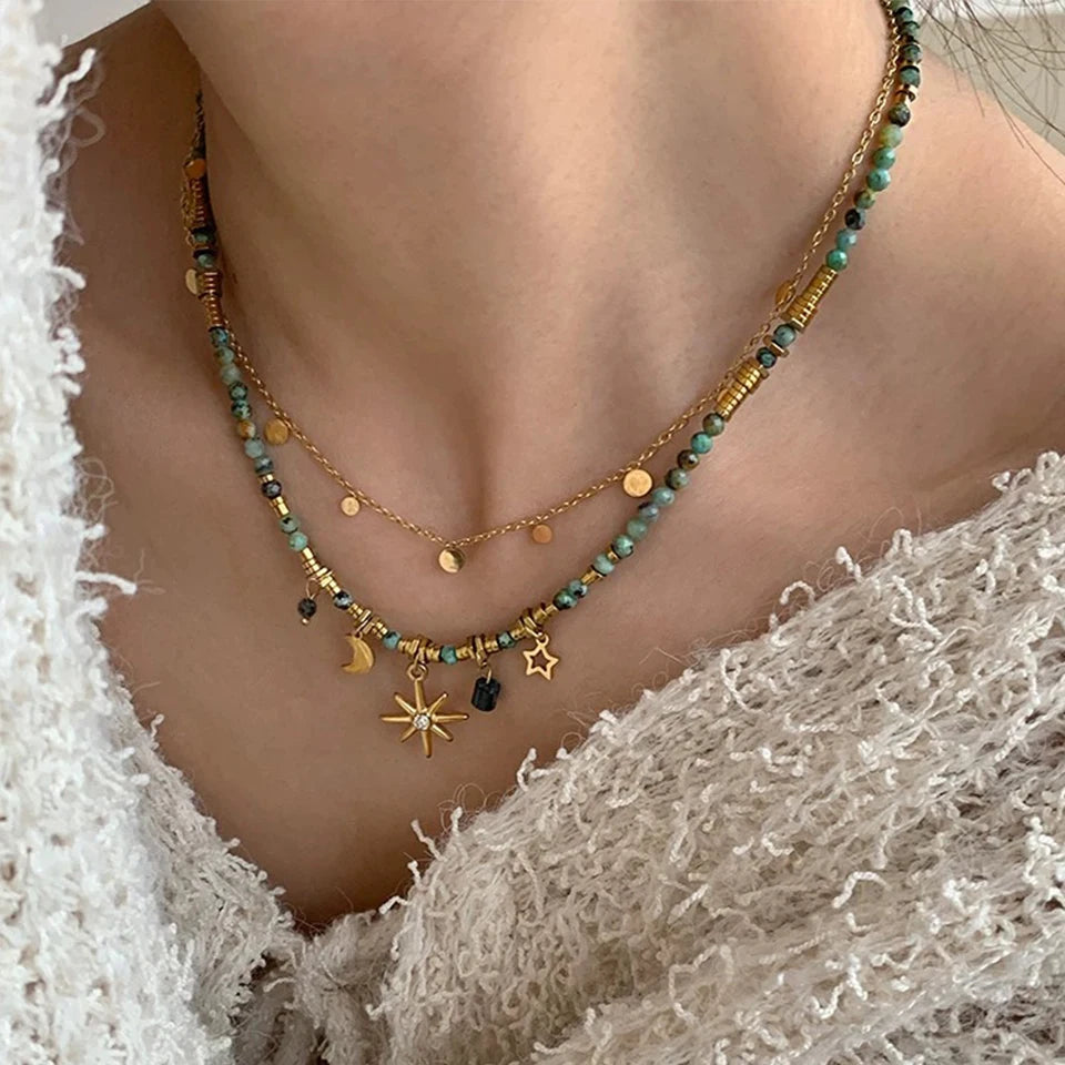 model wearing gold layered star necklace with elegant outfit | Oria Jewel