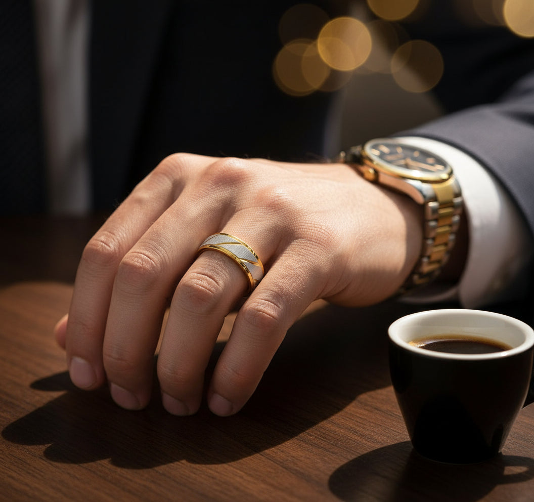 Close-up of a hand wearing a Golden Edge Classic Band ring, with coffee cup and watch visible on the table | Oria Jewel
