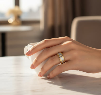 A hand holding a coffee cup, adorned with the Golden Edge Classic Band ring, showcasing its elegant design  | Oria Jewel