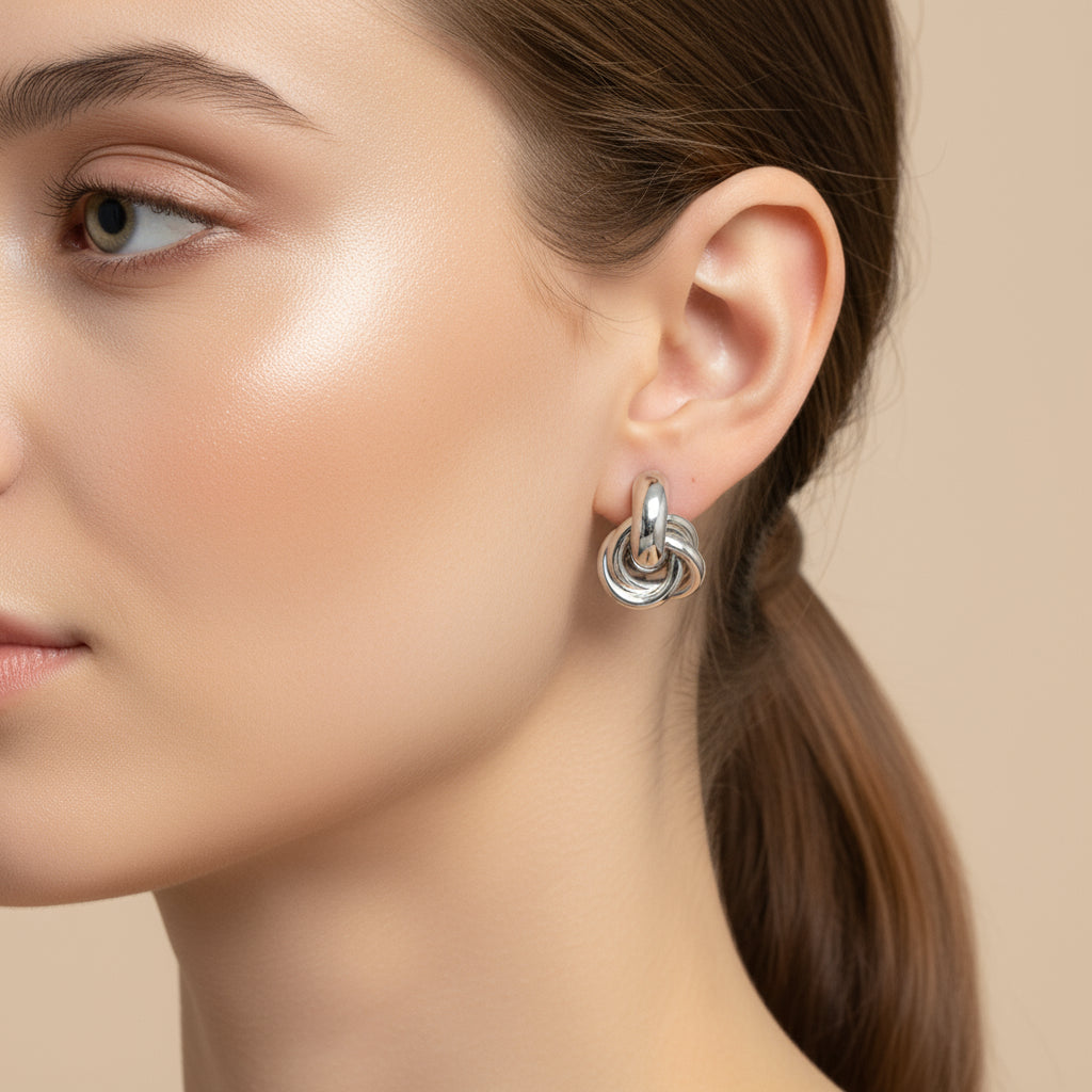 Close-up of a model wearing Elegant Knot Hoop Earrings, showcasing their stylish design and shine | Oria Jewel