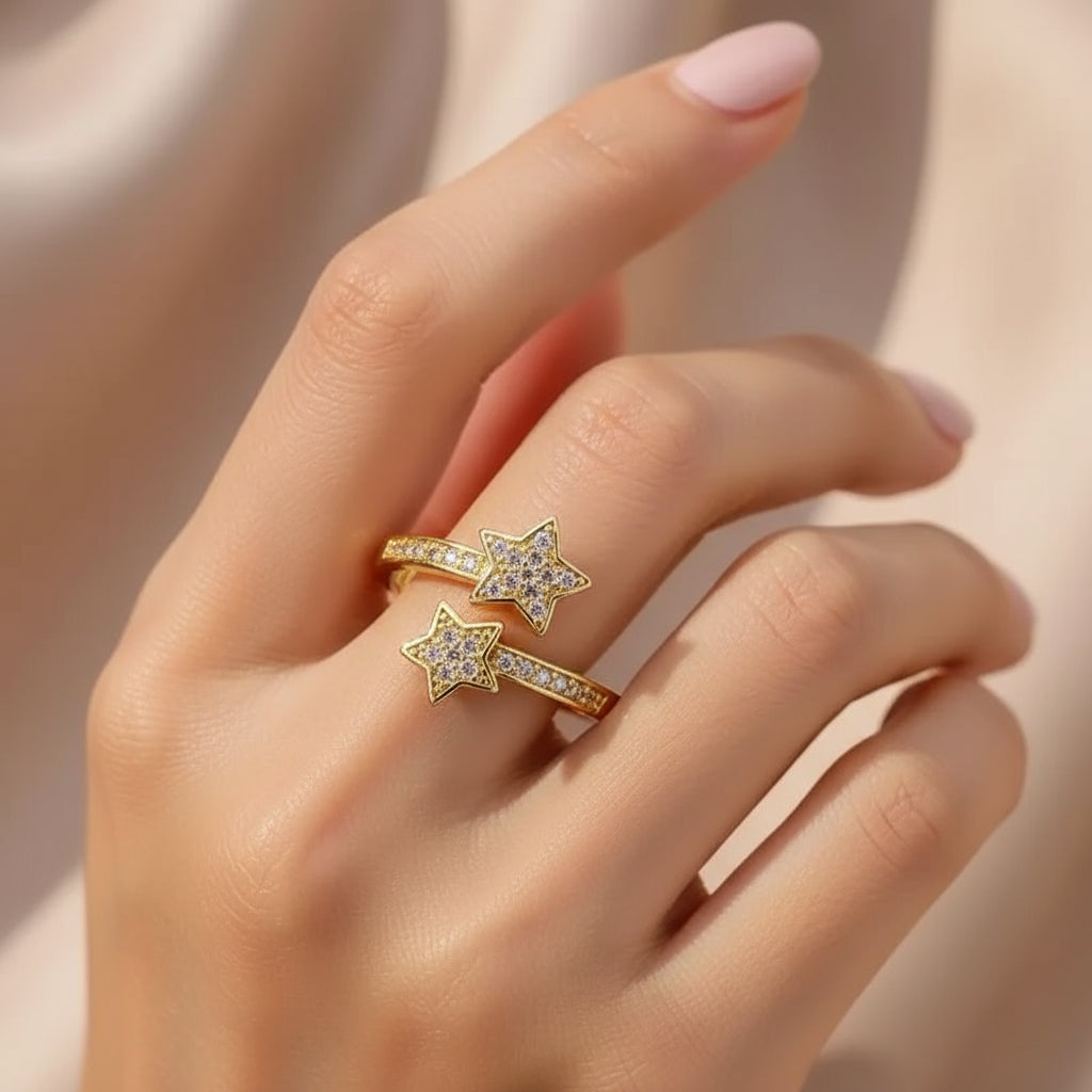 Gold Star Ring displayed on a hand with two star-shaped designs featuring sparkling accents | Oria Jewel