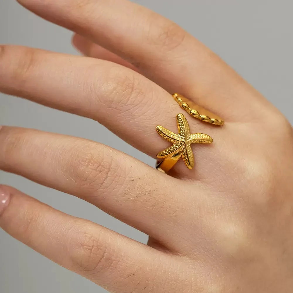 Close-up of a hand wearing the Coastal Charm Gold Ring designed with a starfish motif and elegant details | Oria Jewel