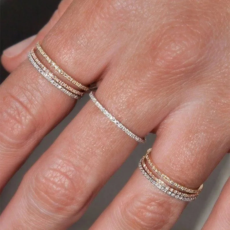 Hand wearing a glittering Sparkle Stacking Ring Set of mixed gold diamond bands | Oria Jewel