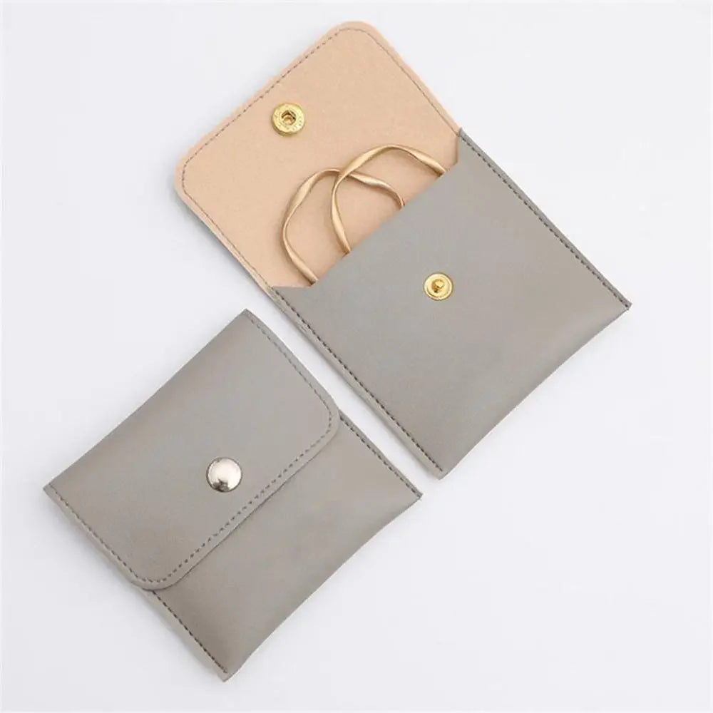 Soft Snap Jewelry Pouch in gray with rings, perfect for storing and gifting jewelry on-the-go.