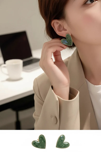 Sage Green Marble Heart Stud Earrings worn by model touching earring indoors | OriaJewel