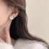Close-up of matte white Camellia Flower Studs on ear, soft light | Oria Jewel