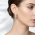 Close-up of Crystal Gold Huggie Earrings on a woman&