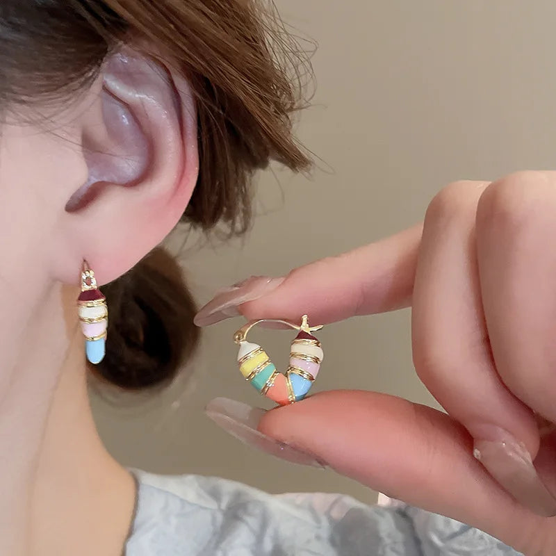 Pastel Colorful Enamel Hoop Earrings worn on ear and held by hand | Oria Jewel