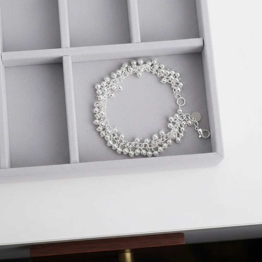 Silver Beaded Cluster Bracelet displayed neatly in a grey velvet jewelry organizer tray, highlighting the dense layering of polished silver beads and delicate chainwork in a circular arrangement | Oria Jewel